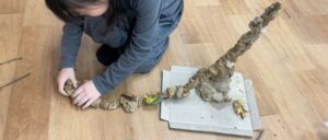 한 아이가 점토와 나뭇가지를 이용해 나무를 만들며 탐구하는 모습 — 유아 점토놀이, 자연물 미술활동